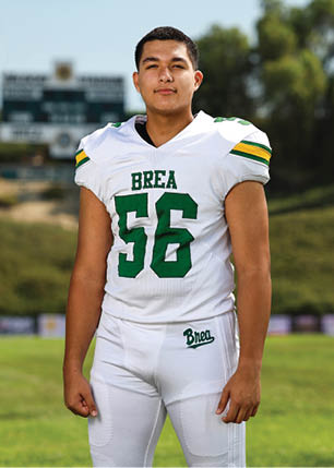 A young man wearing a white and black jersey with the number 14 on it. Description generated by AI