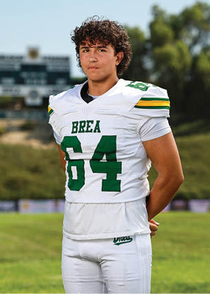 A young man wearing a white and black jersey with the number 14 on it. Description generated by AI