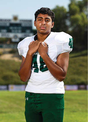 A young man wearing a white and black jersey with the number 14 on it. Description generated by AI