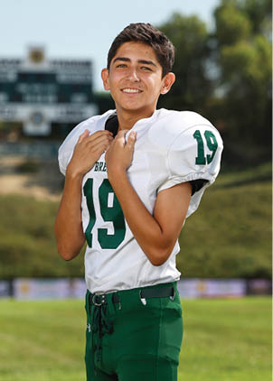 A young man wearing a white and black jersey with the number 14 on it. Description generated by AI