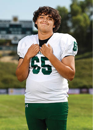 A young man wearing a white and black jersey with the number 14 on it. Description generated by AI