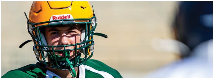A football player wearing a blue and white uniform. Description generated by AI