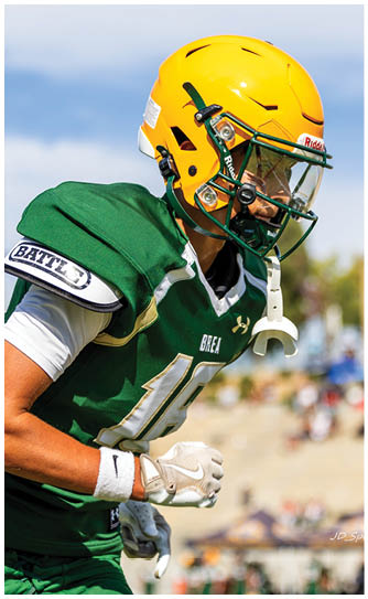 A football player catching a ball. Description generated by AI