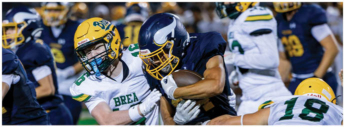 A football player wearing a blue and white uniform. Description generated by AI