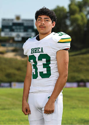 A young man wearing a white and black jersey with the number 14 on it. Description generated by AI