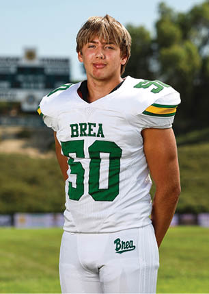 A young man wearing a white and black jersey with the number 14 on it. Description generated by AI