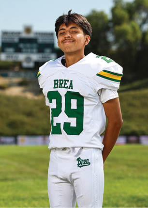 A young man wearing a white and black jersey with the number 14 on it. Description generated by AI