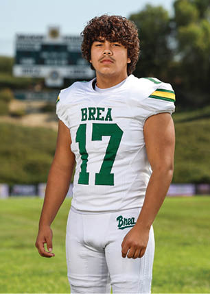 A young man wearing a white and black jersey with the number 14 on it. Description generated by AI