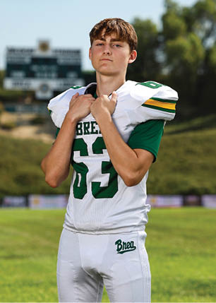 A young man wearing a white and black jersey with the number 14 on it. Description generated by AI