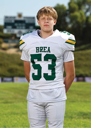 A young man wearing a white and black jersey with the number 14 on it. Description generated by AI