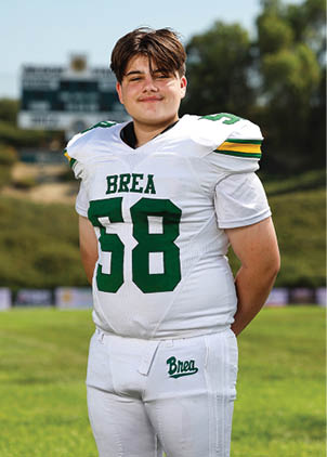 A young man wearing a white and black jersey with the number 14 on it. Description generated by AI