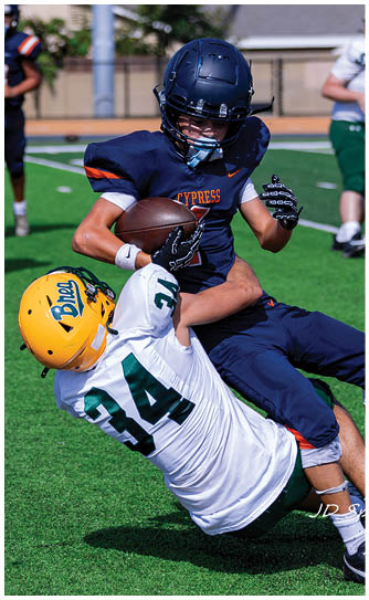 A football player catching a ball. Description generated by AI