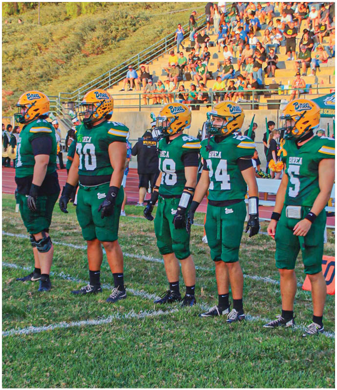 A group of football players wearing black and white uniforms. Description generated by AI