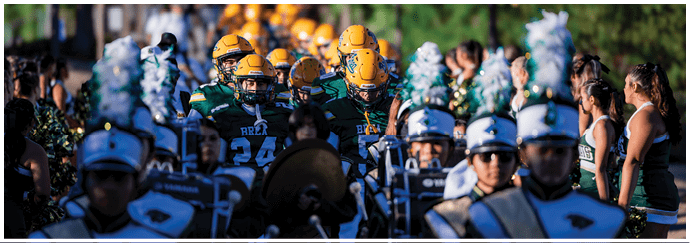 A group of football players on a field. Description generated by AI