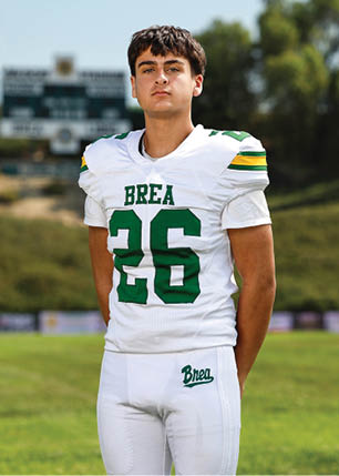 A young man wearing a white and black jersey with the number 14 on it. Description generated by AI