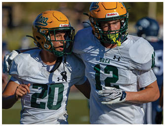 A group of football players on a field. Description generated by AI