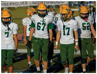 A group of football players on a field. Description generated by AI