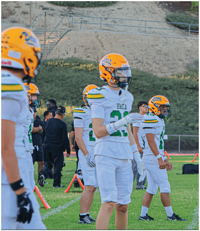 A group of football players wearing black and white uniforms. Description generated by AI
