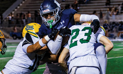 Two men wearing football uniforms are hugging each other on a field. AI generated content