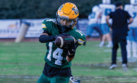 Two men wearing football uniforms are hugging each other on a field. AI generated content