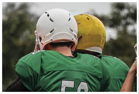 A man wearing a red and white jersey with the number 53 on it. Description generated by AI