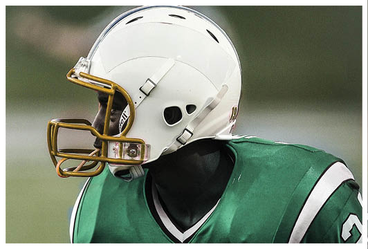 A football player wearing a helmet and a red jersey with the number 24. Description generated by AI