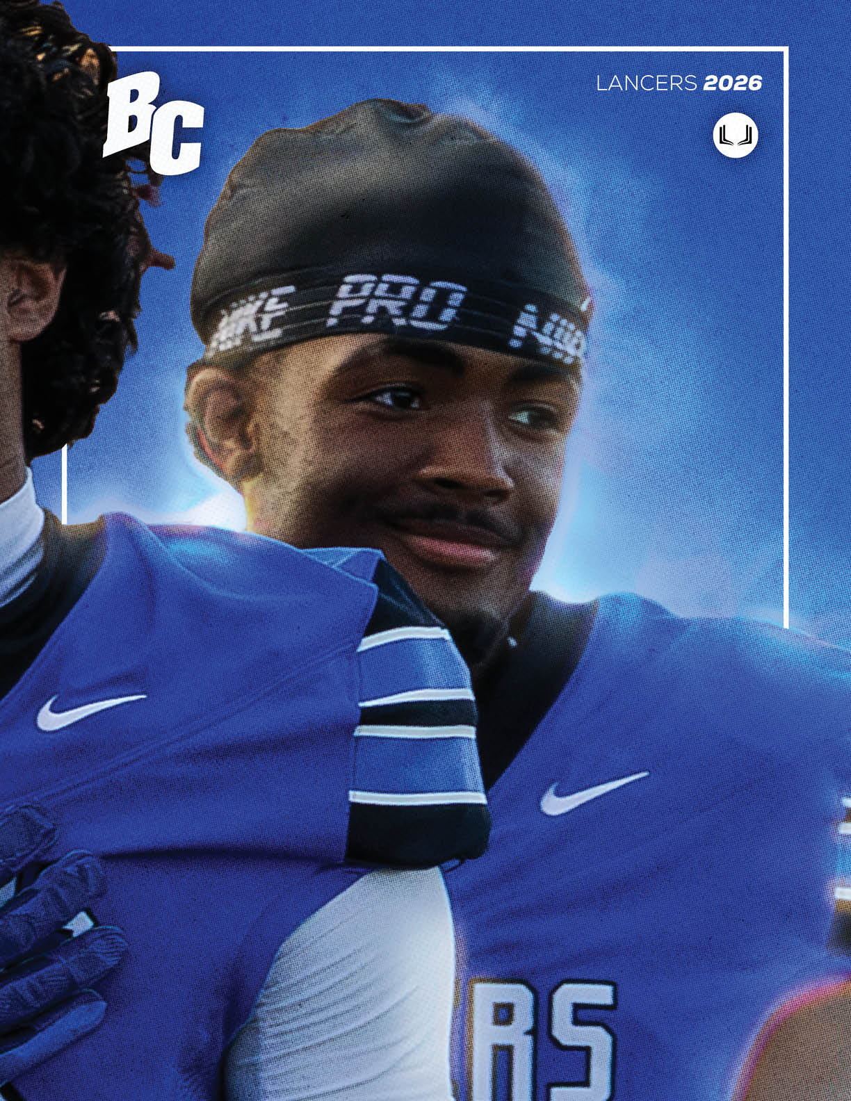Two people wearing blue sports jerseys and headbands are standing close together with one person smiling. Description generated by AI