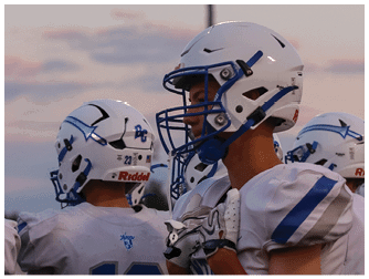 Three people wearing white football helmets with blue faceguards are standing outdoors under a cloudy sky. Description generated by AI