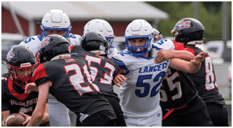 People in sports uniforms are engaged in a close football play on a grassy field. Description generated by AI