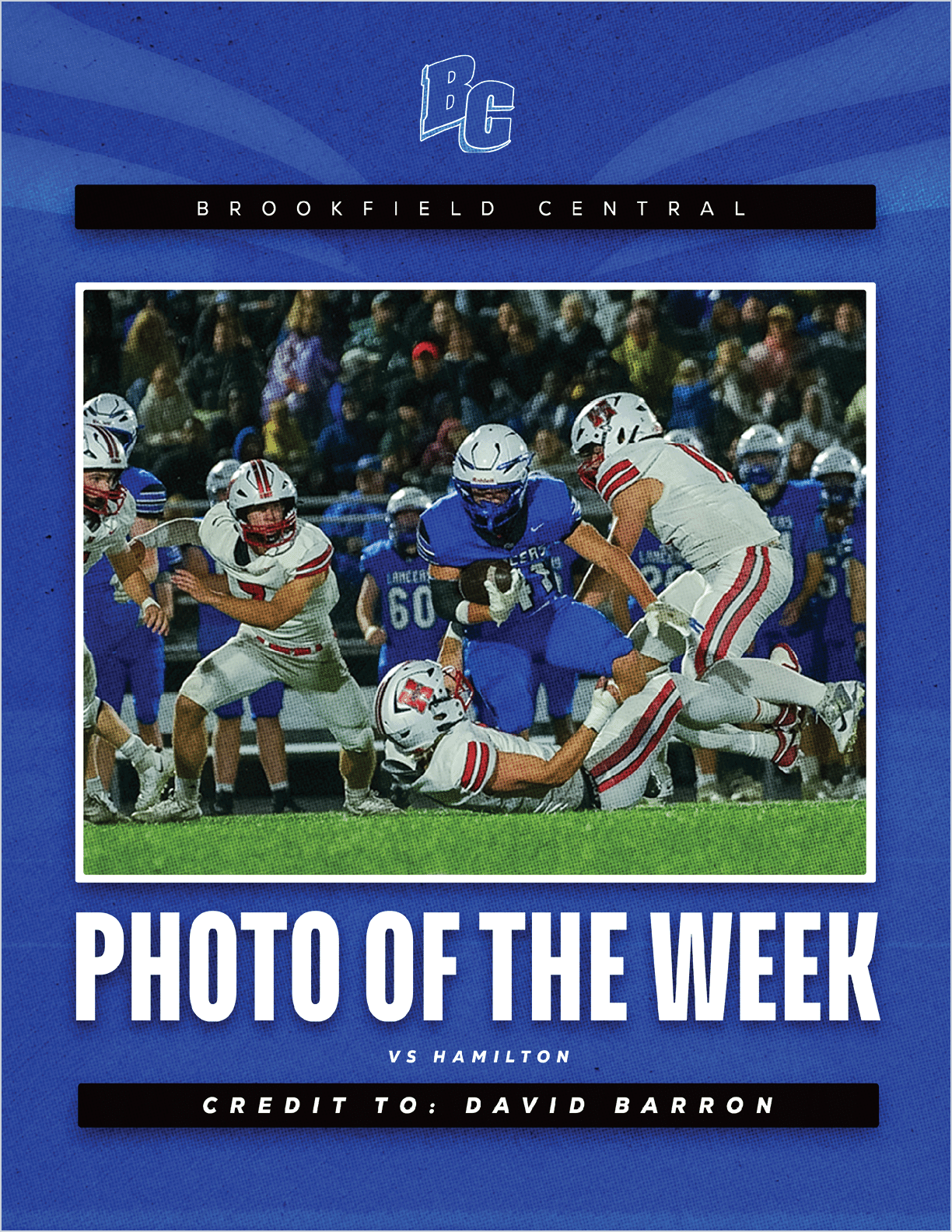A group of people in football uniforms are actively playing on a field with one person in blue running with the ball while others in white attempt to tackle or block. Description generated by AI