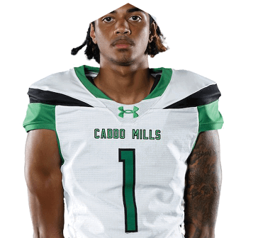 A person wearing a white and green football jersey with the text “CADDO MILLS" and the number 1 on the front. Descripci n generada con IA
