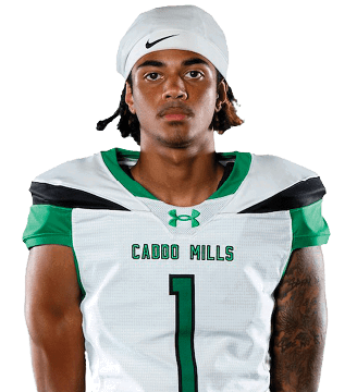 A person wearing a white and green sports uniform with the number one on the front and a white backward cap stands with hands behind their back against a white background. Descripci n generada con IA