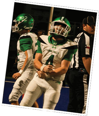 Two people in green and white football uniforms with helmets are on a field, one flexing their arms while the other stands nearby. Descripci n generada con IA