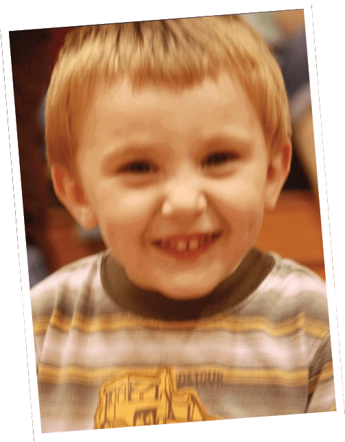 A smiling child wearing a striped shirt with a graphic design is shown in a close-up photo. Descripci n generada con IA