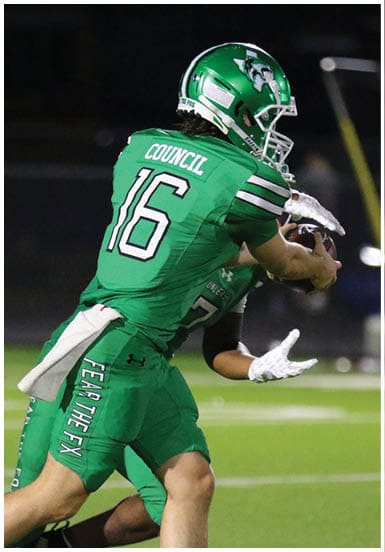 A person wearing a green football uniform with the name “Council" and number 16 on the back is preparing to throw a football on a field. Descripci n generada con IA