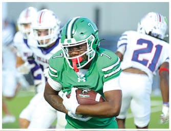 A person wearing a green football helmet and uniform is in the foreground with two people in white football helmets and uniforms blurred in the background. Descripci n generada con IA