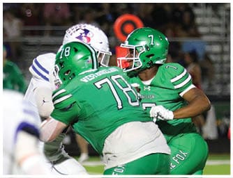 Two people in football uniforms are engaged in a play on the field, with one wearing a green jersey and helmet and the other in a white jersey with blue stripes. Descripci n generada con IA