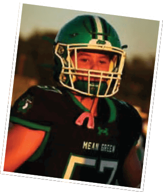 A person wearing a green and black football uniform with the number 57 and a helmet is standing outdoors during sunset. Descripci n generada con IA