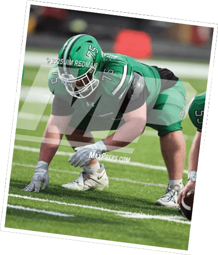 A person in green football gear and helmet is crouched in a ready stance on a grassy field. Descripci n generada con IA