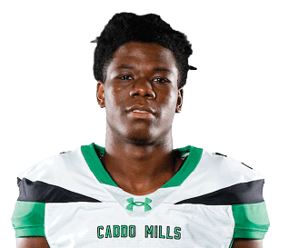 A person stands facing forward wearing a white and green sports uniform with the number seven on the front. Descripci n generada con IA