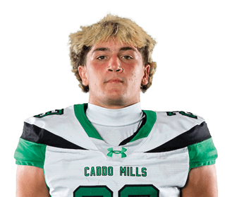 A person with short curly hair is standing with hands behind their back wearing a white and green football uniform with the number 23. Descripci n generada con IA