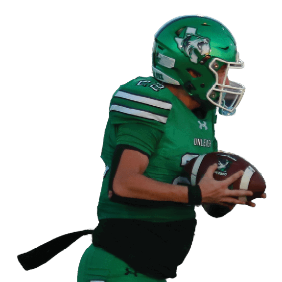A person in green football gear is running on a field while holding a football. Descripci n generada con IA