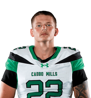 A person stands with hands behind their back wearing a green and white sports uniform with the number 22 and knee braces. Descripci n generada con IA
