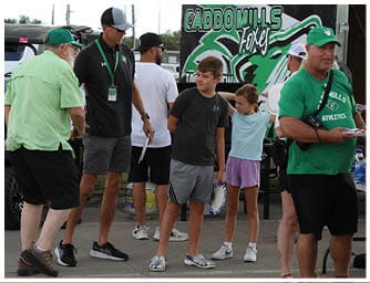 Four people wearing casual shorts and sneakers are standing on a paved surface, with two holding frisbees. Descripci n generada con IA