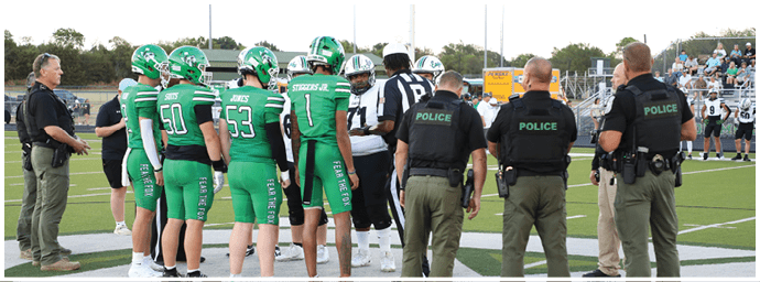 Several people wearing green sports uniforms and others in casual clothing stand on a football field near the center logo. Descripci n generada con IA