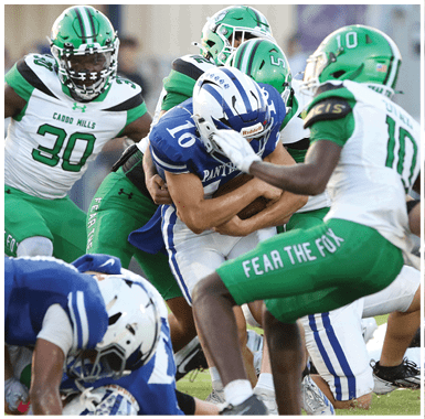 A person in a green football uniform and helmet is running on a field while holding a football. Descripci n generada con IA