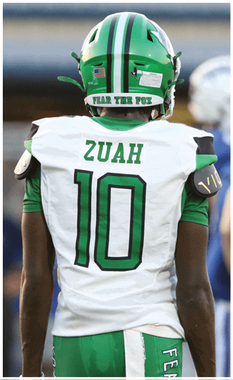 A person wearing a white sports jersey with green and black number 10 and the name ZUAH on the back. Descripci n generada con IA
