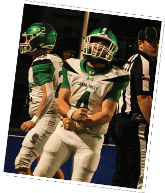 Two people in green and white football uniforms with helmets are on a field, one flexing their arms while the other stands nearby. Descripci n generada con IA