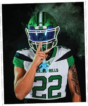 A person wearing a green helmet and black sports uniform with the number 15 is standing on a football field at night. Descripci n generada con IA