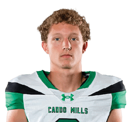 A person stands facing forward wearing a green and white football uniform with the number two on the jersey and green cleats. Descripci n generada con IA